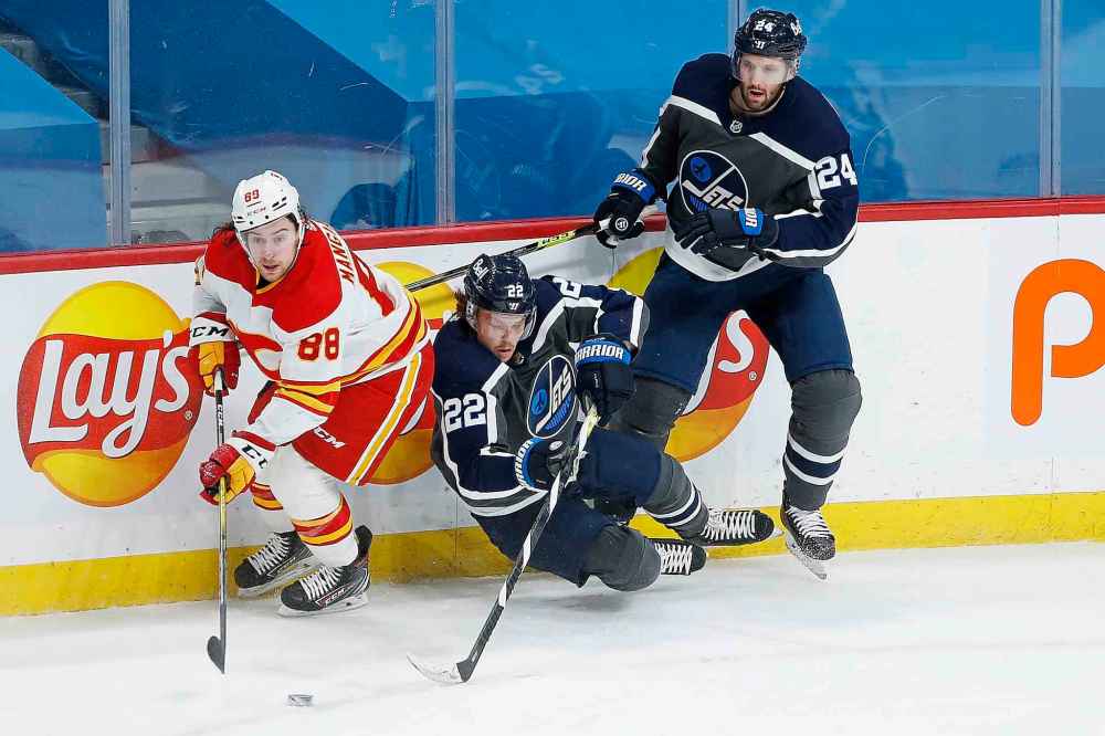 Calgary Flames' Andrew Mangiapane (88) steals the puck from Winnipeg Jets' Mason Appleton (22) and Derek Forbort (24) during third period last Thursday. Appleton now has seven points and boasts a plus-six, while carving out a role as a proficient, two-way performer. (John Woods / The CanadianPress files)