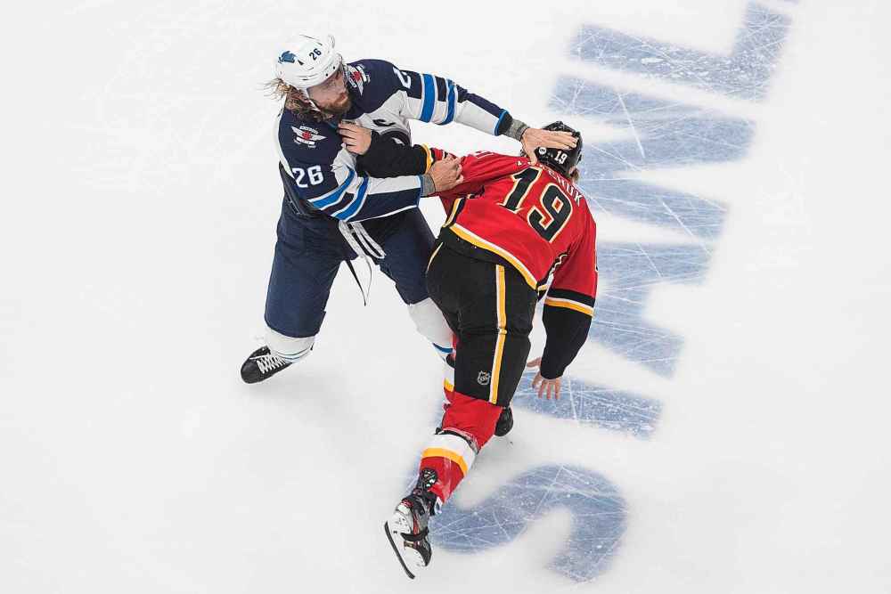 Winnipeg Jets' Blake Wheeler (26) and Calgary Flames' Matthew Tkachuk (19) fight during the first period. (Jason Franson / The Canadian Press)