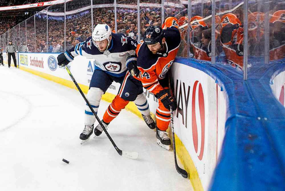 Winnipeg Jets' Anthony Bitetto (2) and Edmonton Oilers' Zack Kassian (44) battle for the puck during the first period. (Jason Franson / The Canadian Press)