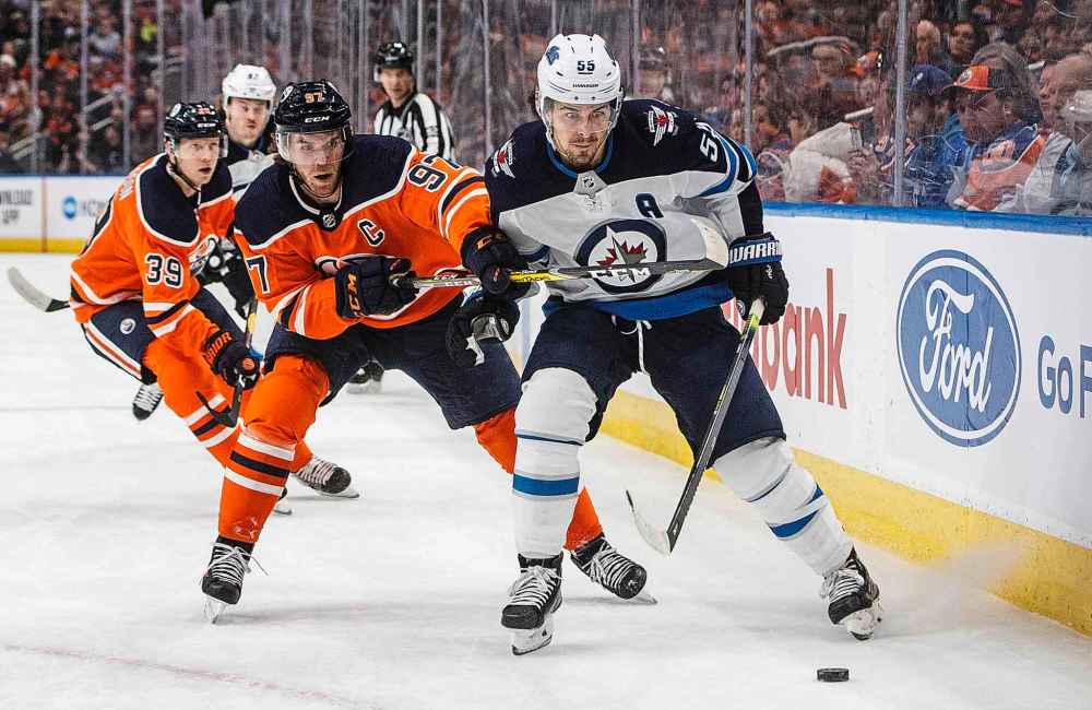 Winnipeg Jets' Mark Scheifele (55) is chased by Edmonton Oilers' Connor McDavid (97) during the first period. (Jason Franson / The Canadian Press)