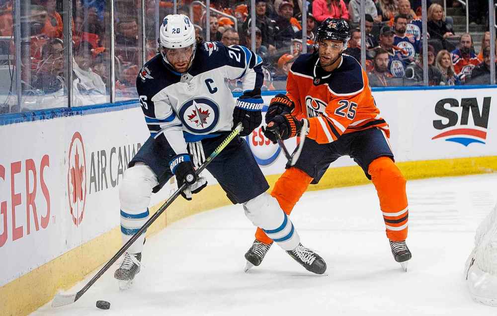 Winnipeg Jets' Blake Wheeler (26) and Edmonton Oilers' Darnell Nurse (25) battle for the puck during the first period. (Jason Franson / The Canadian Press)