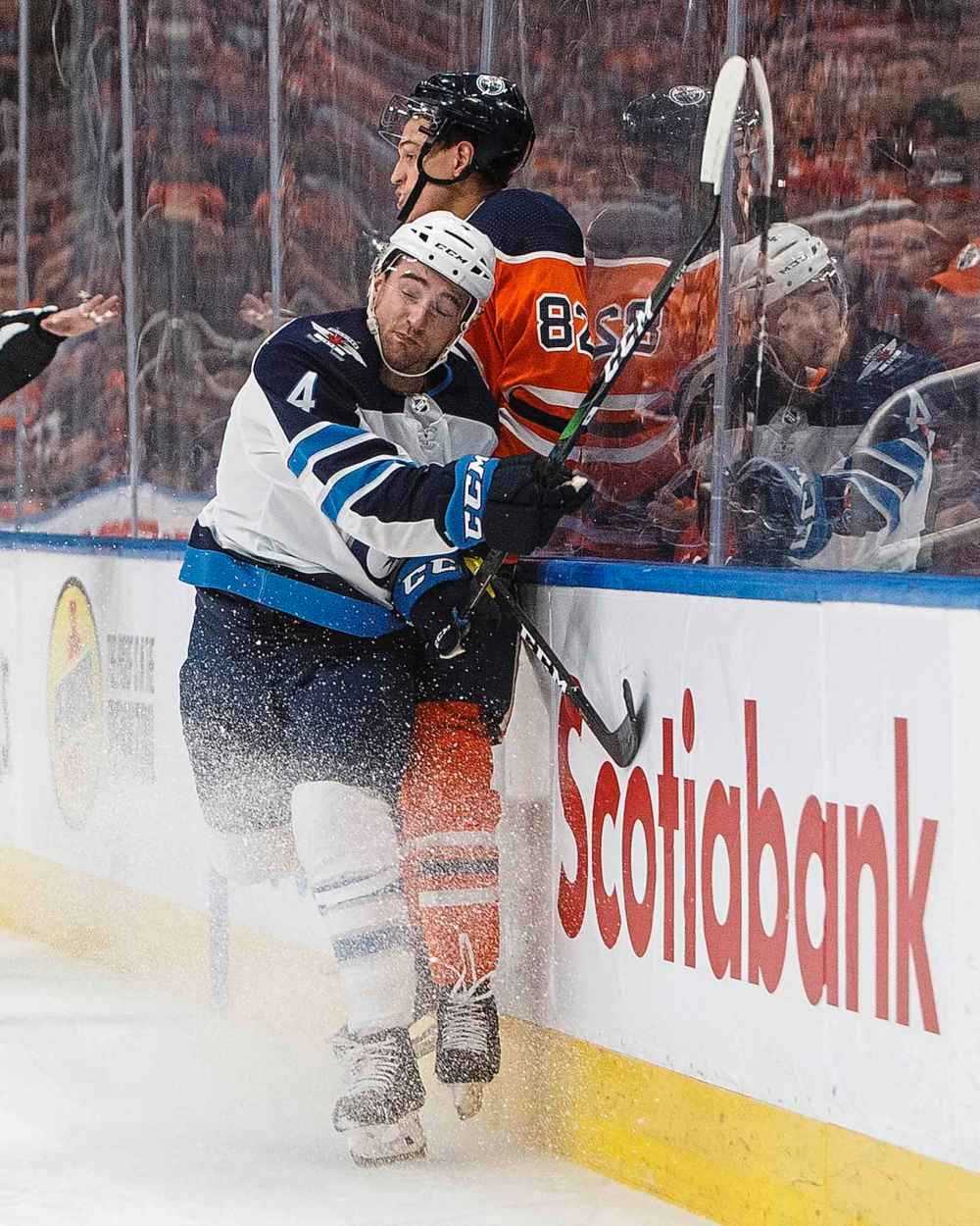 Winnipeg Jets' Neal Pionk (4) checks Edmonton Oilers' Caleb Jones (82) during the second period. (Jason Franson / The Canadian Press)