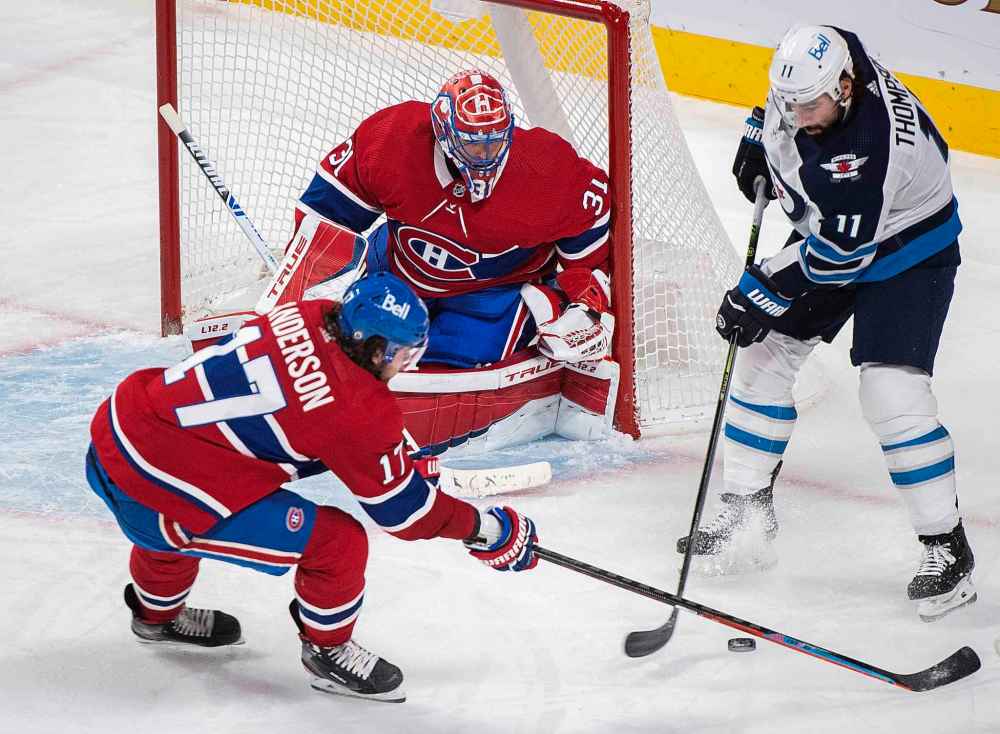 Winnipeg Jets’ Nate Thompson (11) moves in on Montreal Canadiens goaltender Carey Price as Canadiens' Josh Anderson defends during the third period. (Graham Hughes / The Canadian Press)