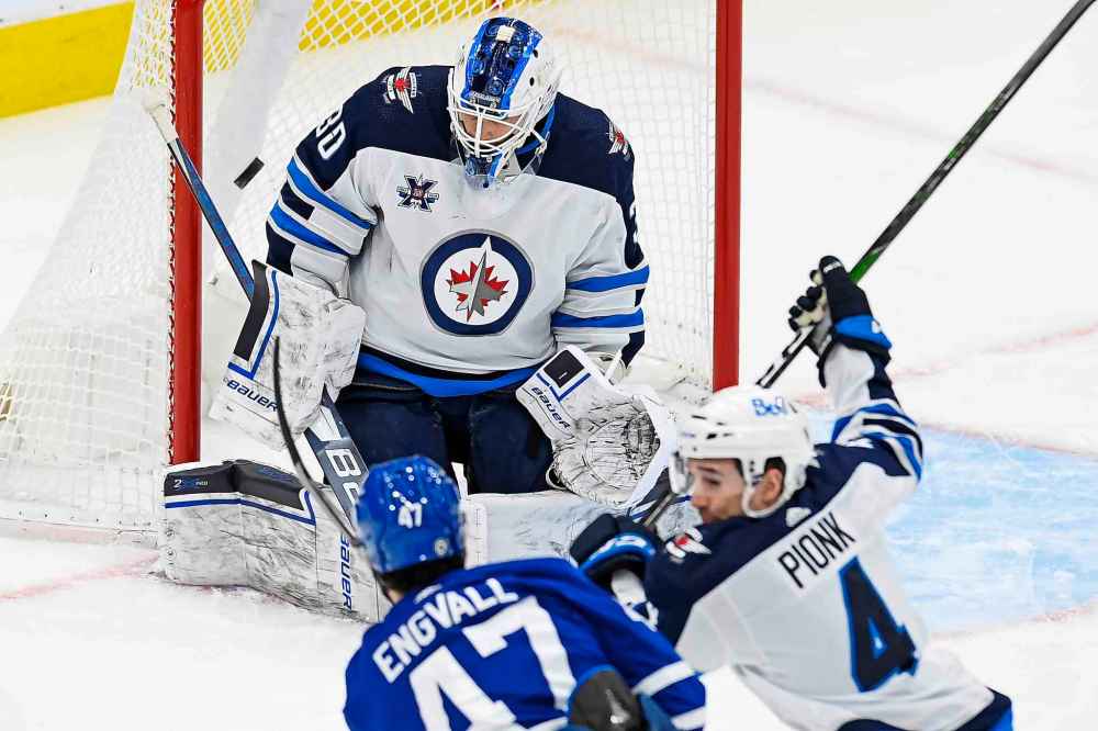 Toronto Maple Leafs left wing Pierre Engvall (47) scores what would be determined to be a disallowed goal on Winnipeg Jets goaltender Laurent Brossoit (30) as Winnipeg Jets defenceman Neal Pionk (4) defends during the first period. (Frank Gunn / The Canadian Press)