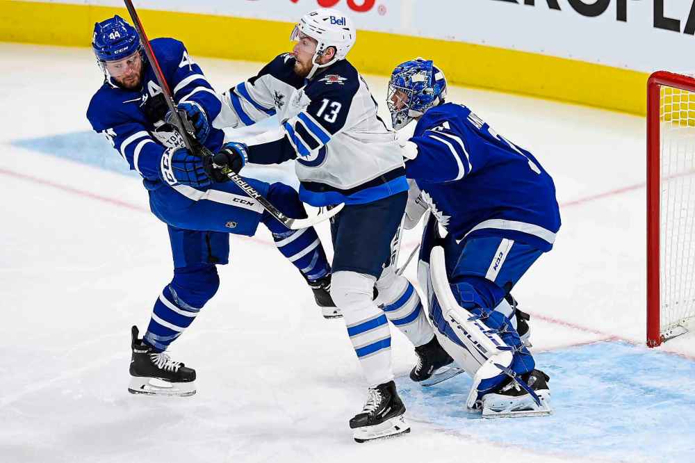 Toronto Maple Leafs goaltender Frederik Andersen (31) tries look around a battle between Winnipeg Jets centre Pierre-Luc Dubois (13) and Maple Leafs defenceman Morgan Rielly (44) during the first period. (Frank Gunn / The Canadian Press)