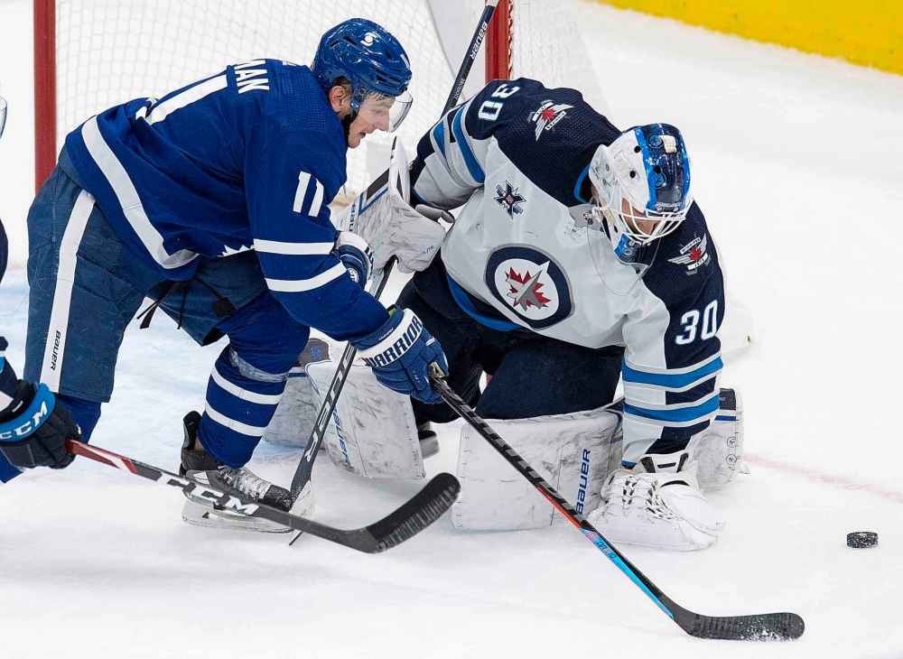 Toronto Maple Leafs left wing Zach Hyman (11) chases the puck past Winnipeg Jets goaltender Laurent Brossoit (30) during the second period. (Frank Gunn / The Canadian Press)