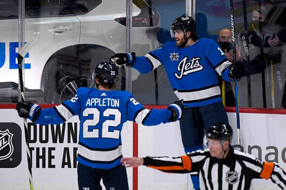 Winnipeg Jets' Adam Lowry (17) celebrates his first period goal against the Edmonton Oilers with teammate Mason Appleton (22) Sunday. “It feels good. But a goal and minus two... it’s tough, you want to contribute but I didn’t win faceoffs and couldn’t keep the puck out of our net,” he said. (Fred Greenslade / The Canadian Press)