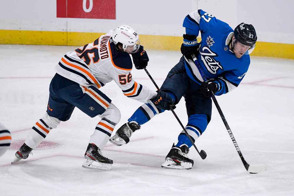 Winnipeg Jets' Nikolaj Ehlers (27) carries by puck past Edmonton Oilers' Kailer Yamamoto (56) during the first period. (Fred Greenslade / The Canadian Press)