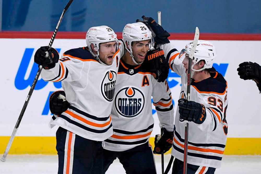 Edmonton Oilers' Leon Draisaitl (29) celebrates his game-winning goal against the Winnipeg Jets with teammates Darnell Nurse (25) and Ryan Nugent-Hopkins (93) during third period NHL action in Winnipeg on Sunday Jan. 24, 2021. (Fred Greenslade / The Canadian Press)