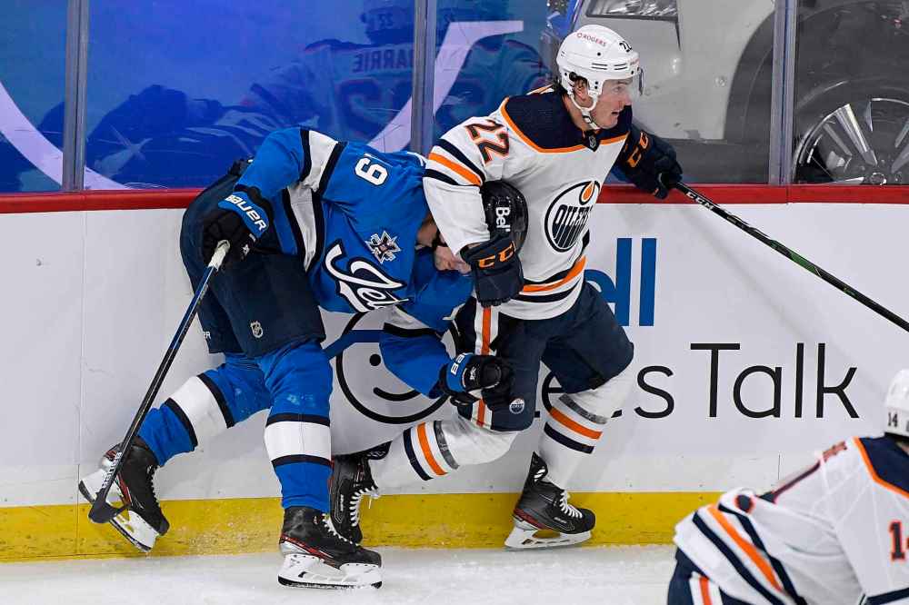 Winnipeg Jets' David Gustafsson (19) is checked by Edmonton Oilers’ Tyson Barrie (22) during the first period. (Fred Greenslade / The Canadian Press)
