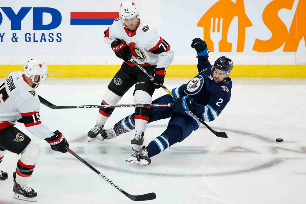 Winnipeg Jets' Dylan DeMelo (2) and Ottawa Senators' Chris Tierney (71) collide during first period NHL action in Winnipeg on Saturday, January 23, 2021. (John Woods / The Canadian Press)
