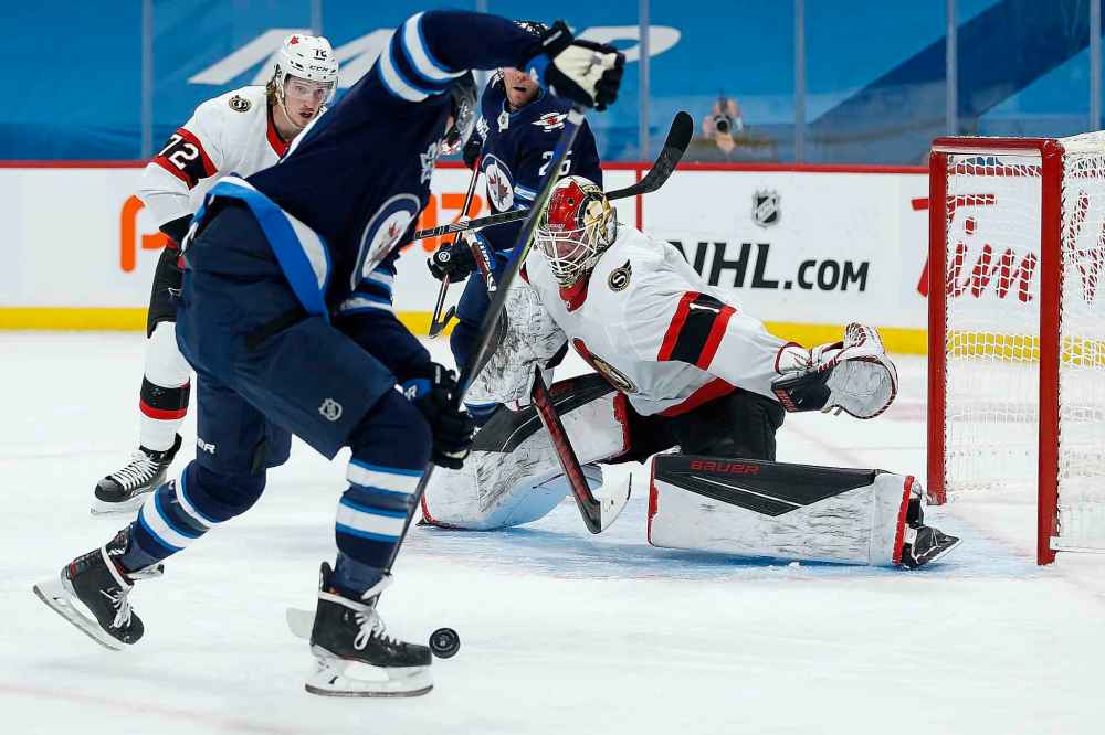 Ottawa Senators goaltender Marcus Hogberg (1) keeps his eye on Winnipeg Jets' Nikolaj Ehlers (27) during second period NHL action in Winnipeg on Saturday, January 23, 2021. (John Woods / The Canadian Press)