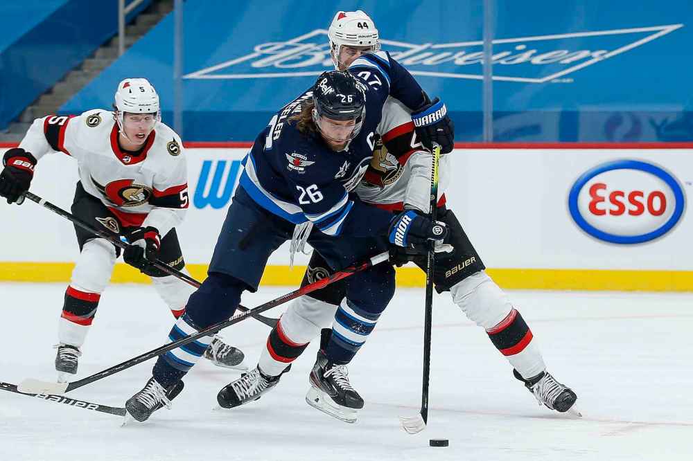 Winnipeg Jets' Blake Wheeler (26) attempts to get past Ottawa Senators' Erik Gudbranson (44) during second period NHL action in Winnipeg on Saturday, January 23, 2021. (John Woods / The Canadian Press)