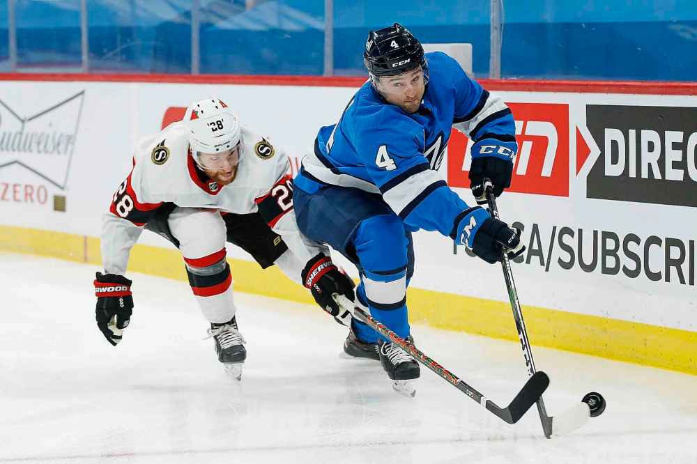 Ottawa Senators' Connor Brown (28) chases Winnipeg Jets' Neal Pionk (4) during the first period. (John Woods / The Canadian Press)