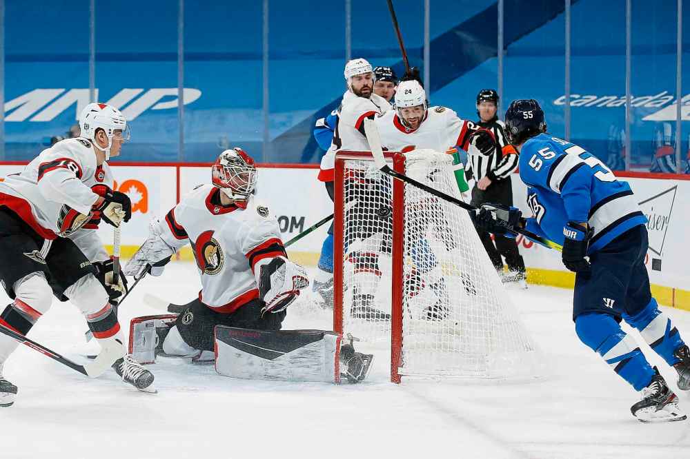 Winnipeg Jets defenceman Derek Forbort skates behind Ottawa Senators left  wing Brady Tkachuk as he celebrates his second goal during third period NHL  action Monday April 12, 2021 in Ottawa. THE CANADIAN