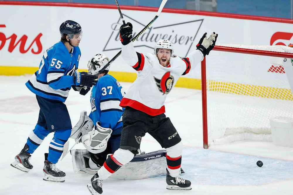 Ottawa Senators' Chris Tierney (71) celebrates Brady TkachukÕs (7) game winning goal against Winnipeg Jets goaltender Connor Hellebuyck (37) and Mark Scheifele (55) with 8.2 seconds left in the third period. (John Woods / The Canadian Press)