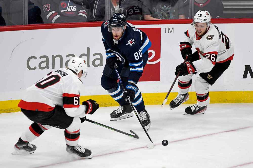 CP
Winnipeg Jets' Pierre-Luc Dubois (80) carries the puck around Ottawa Senators’ Lassi Thomson (60) and Erik Brannstrom (26) during the third period. (Fred Greenslade / The Canadian Press)