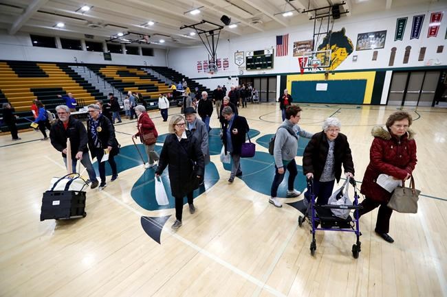 Local residents enter an Iowa Democratic caucus at Hoover High School, Monday, Feb. 3, 2020, in Des Moines, Iowa. (AP Photo/Charlie Neibergall)