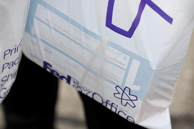 Julie Stewart, precinct captain in Waukee, Iowa, carries a bag of precinct preference cards back to her car after trying to drop them off at the Iowa Democratic Party headquarters, Tuesday, Feb. 4, 2020, in Des Moines, Iowa. (AP Photo/Charlie Neibergall)