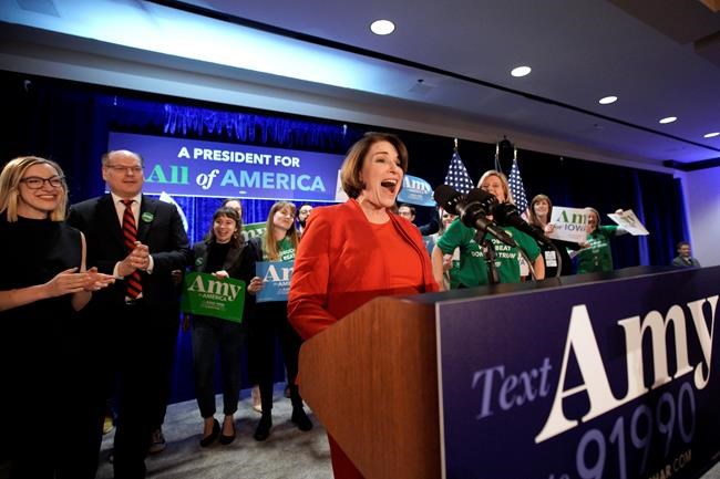 Democratic presidential candidate Sen. Amy Klobuchar, D-Minn., speaks to supporters as she is accompanied by her husband John Bessler, second left, and daughter Abigail Klobuchar Bessler, left, at her caucus night campaign rally in Des Moines, Iowa, Monday, Feb. 3, 2020. (AP Photo/Nati Harnik)