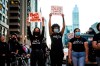 Protesters holds placards Saturday afternoon, May 30, 2020 in Chicago, I.L., as they join national outrage over the death of George Floyd, who died in police custody on Memorial Day in Minneapolis.(Ashlee Rezin Garcia/Chicago Sun-Times via AP)