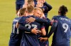 Chicago Fire defender Francisco Calvo (5) hugs forward Robert Beric (27) in celebration of Beric's goal against the New England Revolution during the first half of an MLS soccer match in Chicago, Saturday, April 17, 2021. (AP Photo/Mark Black)