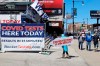 A person stands with a sign related to COVID-19 testing as Chicago Cubs fans pass by outside of Wrigley Field on the opening day baseball game between the Chicago Cubs and the Pittsburgh Pirates, Thursday, April 1, 2021 at Chicago. Fans are back at the ballpark after they were shut out during the regular season last year because of the coronavirus pandemic. (AP Photo/Shafkat Anowar)