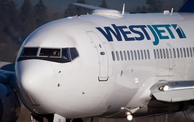 A pilot taxis a Westjet Boeing 737-700 plane to a gate after arriving at Vancouver International Airport in Richmond, B.C., on February 3, 2014. WestJet Airlines Ltd. is raising its surcharges on domestic flights in response to a 30 per cent rate increase by Nav Canada, which operates air navigation across the country. The airline says it has hiked the fee it charges for air traffic control services by between $4 and $7 per passenger, depending on flight duration. THE CANADIAN PRESS/Darryl Dyck