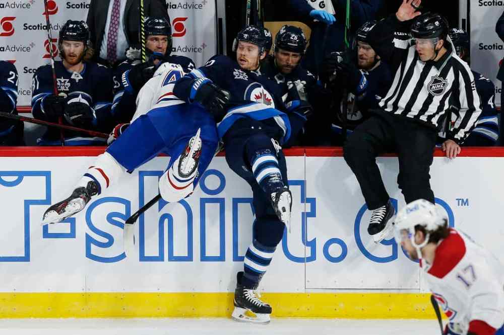 Winnipeg Jets' Mason Appleton and Montreal Canadiens' Joel Edmundson collide at the Jets bench during the first period. THE CANADIAN PRESS/John Woods