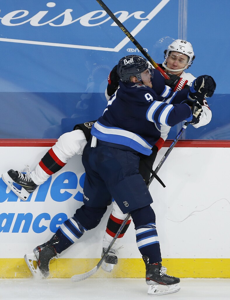 Winnipeg Jets' Andrew Copp hits Ottawa Senators' Nikita Zaitsev during the second period. THE CANADIAN PRESS/John Woods