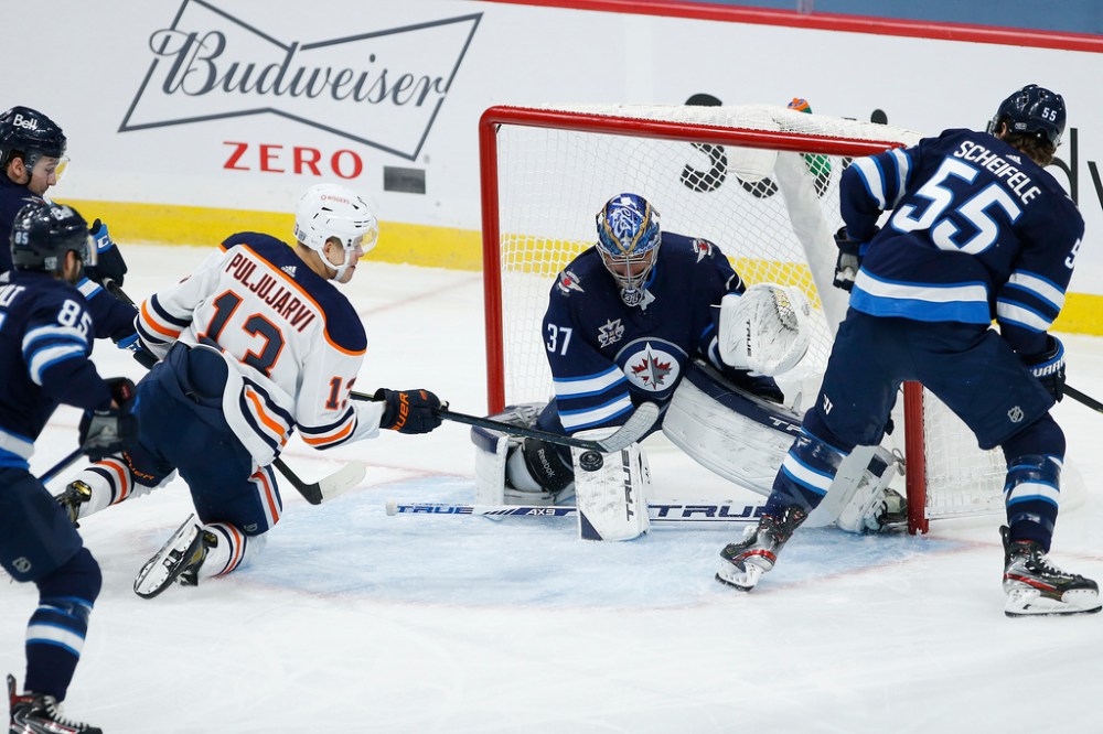 JOHN WOODS / WINNIPEG FREE PRESS
Winnipeg Jets goaltender Connor Hellebuyck saves a shot from Edmonton Oilers' Jesse Puljujarvi as Jets’ Mark Scheifele defends during the first period Tuesday.