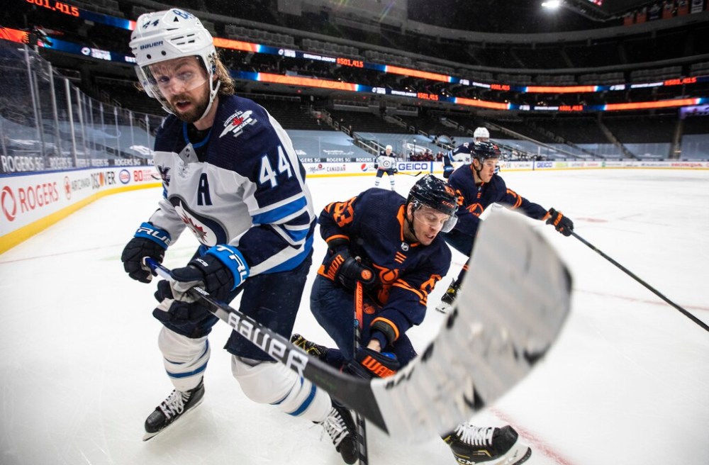 Edmonton Oilers' Tyler Ennis and Winnipeg Jets' Josh Morrissey battle for the puck during the second period. THE CANADIAN PRESS/Jason Franson
