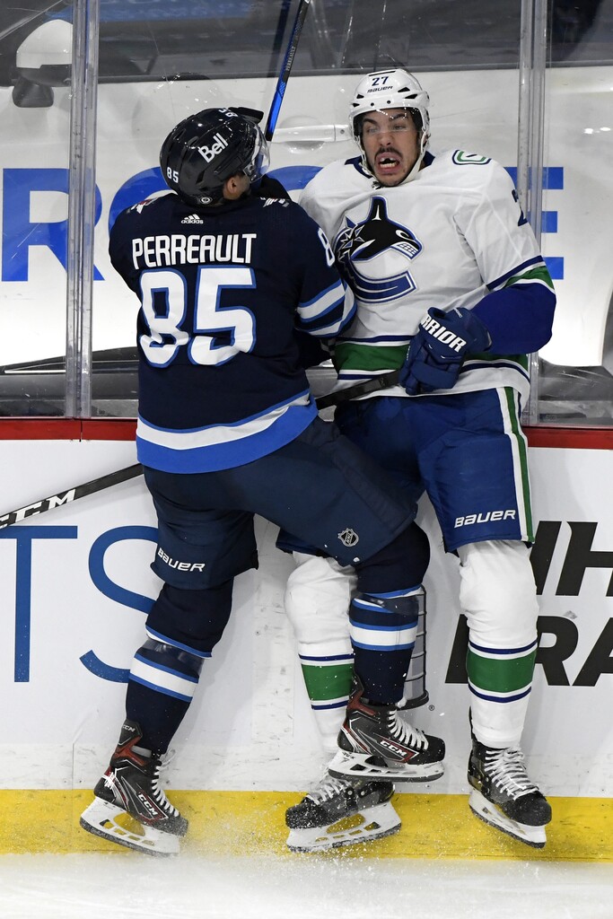 CP
Winnipeg Jets' Mathieu Perreault checks Vancouver Canucks’ Travis Hamonic during the second period. THE CANADIAN PRESS/Fred Greenslade