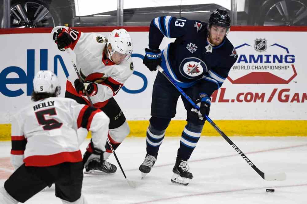 Winnipeg Jets' Pierre-Luc Dubois looks to pass the puck past Ottawa Senators' Ryan Dzingel during the first period. THE CANADIAN PRESS/Fred Greenslade