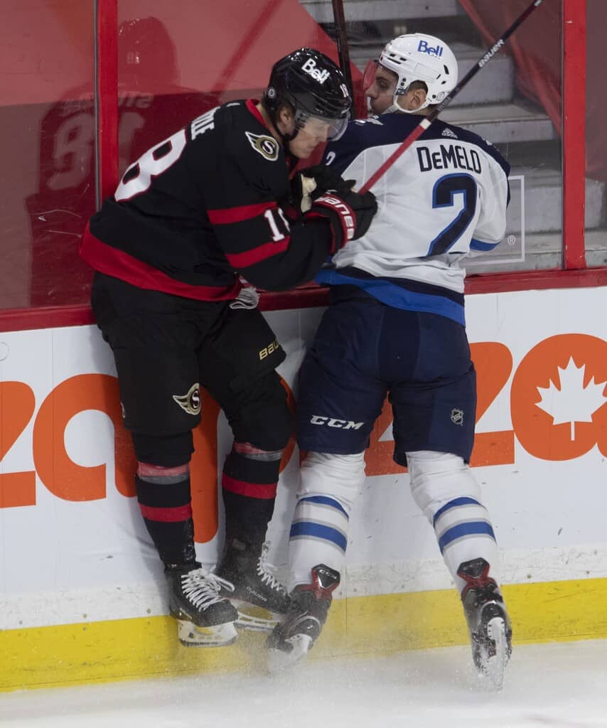 Ottawa Senators left wing Tim Stützle collides with Winnipeg Jets defenceman Dylan DeMelo along the boards during the first period. THE CANADIAN PRESS/Adrian Wyld