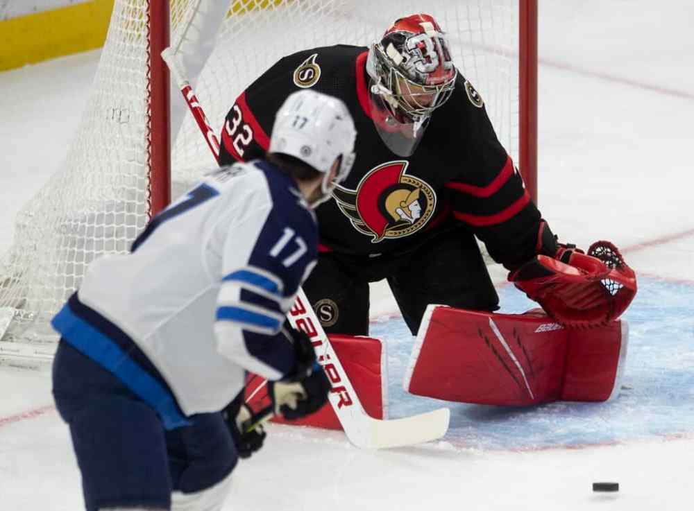 Winnipeg Jets centre Adam Lowry pressures Ottawa Senators goaltender Filip Gustavsson during the first period. THE CANADIAN PRESS/Adrian Wyld