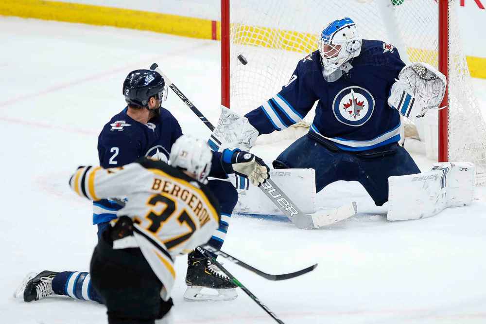 THE CANADIAN PRESS/John Woods
Boston Bruins' Patrice Bergeron scores on Winnipeg Jets goaltender Laurent Brossoit as Anthony Bitetto defends during the first period.