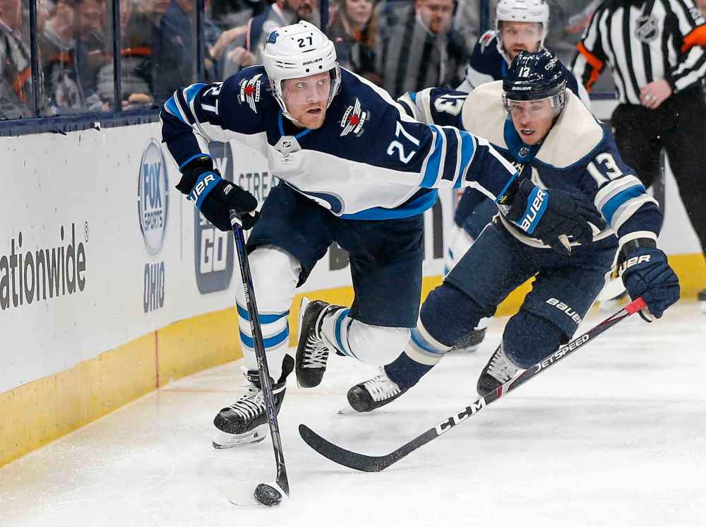 (AP Photo/Jay LaPrete)
Winnipeg Jets' Nikolaj Ehlers tries to clear the puck as Columbus Blue Jackets' Cam Atkinson chases him behind the net during the second period.