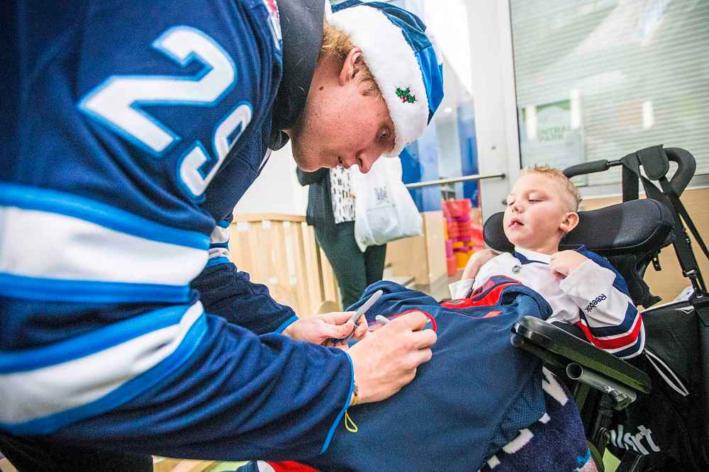 MIKAELA MACKENZIE / WINNIPEG FREE PRESS
Patrik Laine signs a jersey for five-year-old Creighton Deakin.