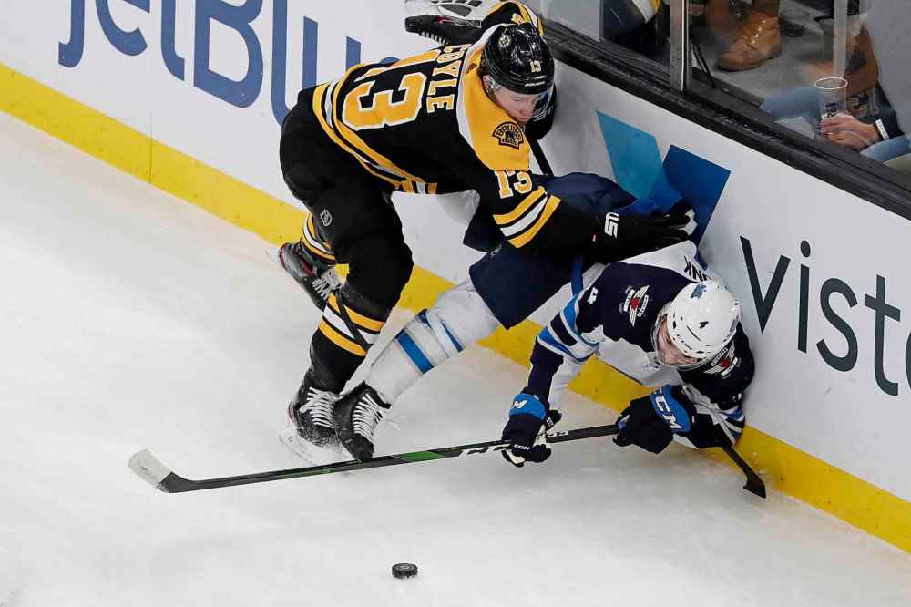 (AP Photo/Elise Amendola)
Boston Bruins centre Charlie Coyle and Winnipeg Jets defenceman Neal Pionk compete for the puck along the boards during the first period Thursday in Boston.