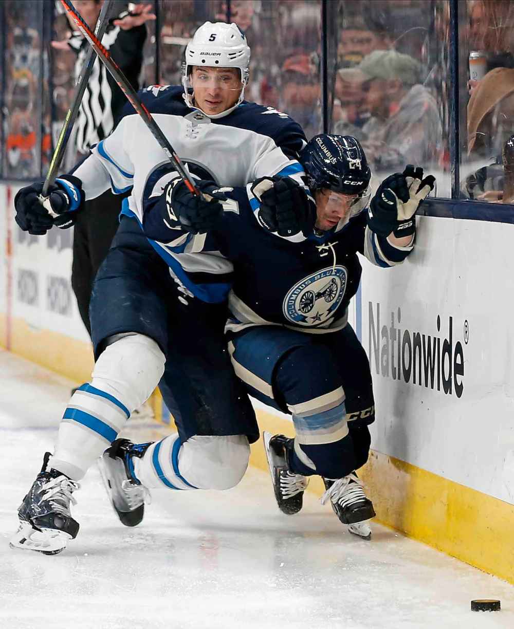 (AP Photo/Jay LaPrete)
Winnipeg Jets' Luca Sbisa, left, checks Columbus Blue Jackets' Nathan Gerbe during the second period.