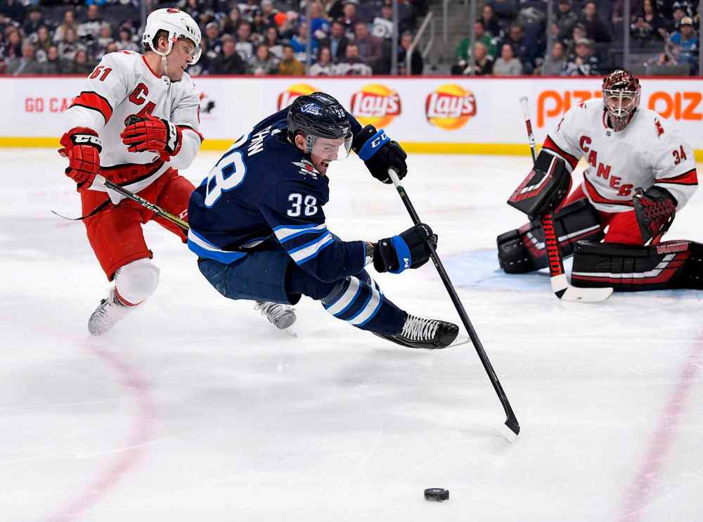 THE CANADIAN PRESS/Fred Greenslade
Winnipeg Jets' Logan Shaw and Carolina Hurricanes' Jake Gardiner battle for the puck in front of goaltender Petr Mrazek during the second period.