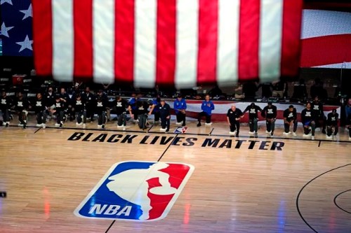 Members of the Milwaukee Bucks and Orlando Magic kneel during the national anthem before an NBA basketball first round playoff game Saturday, Aug. 29, 2020, in Lake Buena Vista, Fla. THE CANADIAN PRESS/AP, Ashley Landis