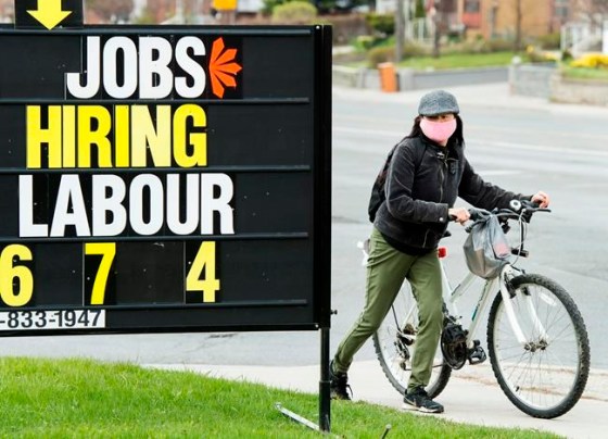 A woman checks out a jobs advertisement sign during the COVID-19 pandemic in Toronto on Wednesday, April 29, 2020. Statistics Canada will report this morning how the country's labour market performed in July as more parts of the economy were allowed to reopen. THE CANADIAN PRESS/Nathan Denette