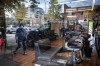 A man cleans inside a closed barbershop as a pedestrian wearing a face mask is reflected in the shop's window, in Burnaby, B.C., on Wednesday, May 6, 2020. THE CANADIAN PRESS/Darryl Dyck