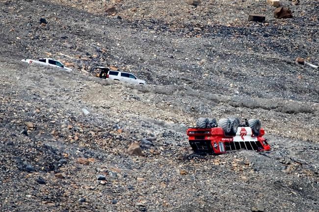 RCMP attend the scene of a sightseeing bus rollover at the Columbia Icefields near Jasper, Alta., Sunday, July 19, 2020. Three people were killed and more than a dozen others were critically injured when a glacier sightseeing bus rolled at one of the most popular attractions in the Rocky Mountains, the Columbia Icefield. RCMP said the rollover happened early Saturday afternoon. Pictures posted online by people at the scene showed one of the attraction's big-wheeled ice explorers on its roof down a moraine embankment. THE CANADIAN PRESS/Jeff McIntosh
