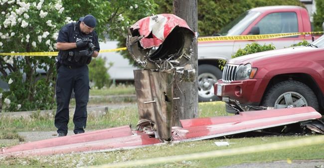 An RCMP photographer photographs the remains of a downed Canadian Forces Snowbird plane in Kamloops, B.C., Sunday, May 17, 2020. One person has died and another is badly injured after a Canadian Forces Snowbird plane crashed in a residential area of Kamloops, B.C., while on a cross-country tour meant to impart hope during the COVID-19 pandemic. THE CANADIAN PRESS/Jonathan Hayward