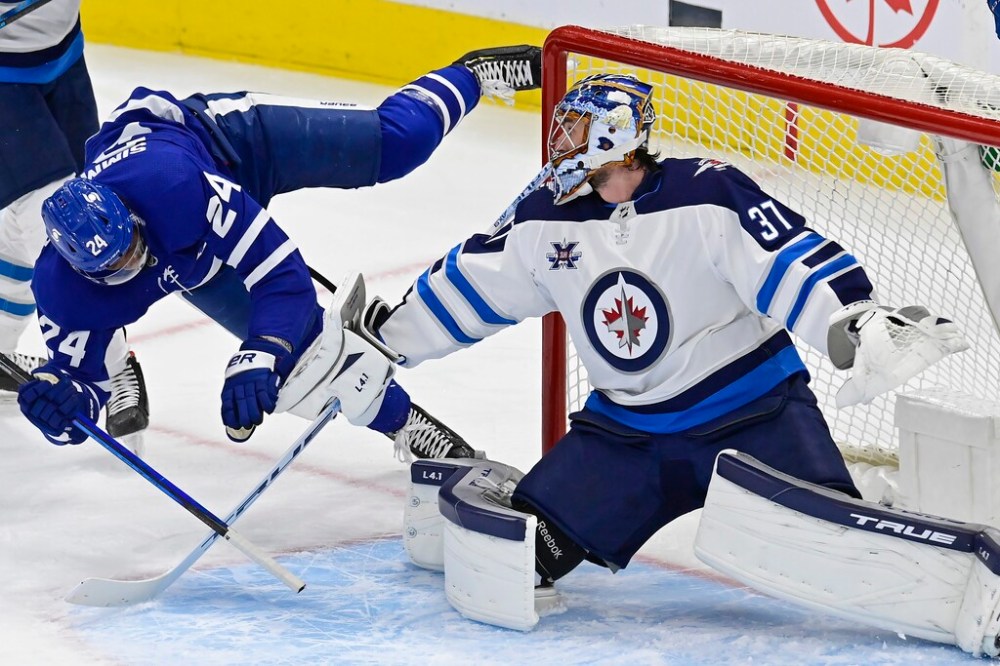 CP
Toronto Maple Leafs' Wayne Simmonds trips over the pad of Winnipeg Jets goaltender Connor Hellebuyck during the second period. THE CANADIAN PRESS/Frank Gunn
