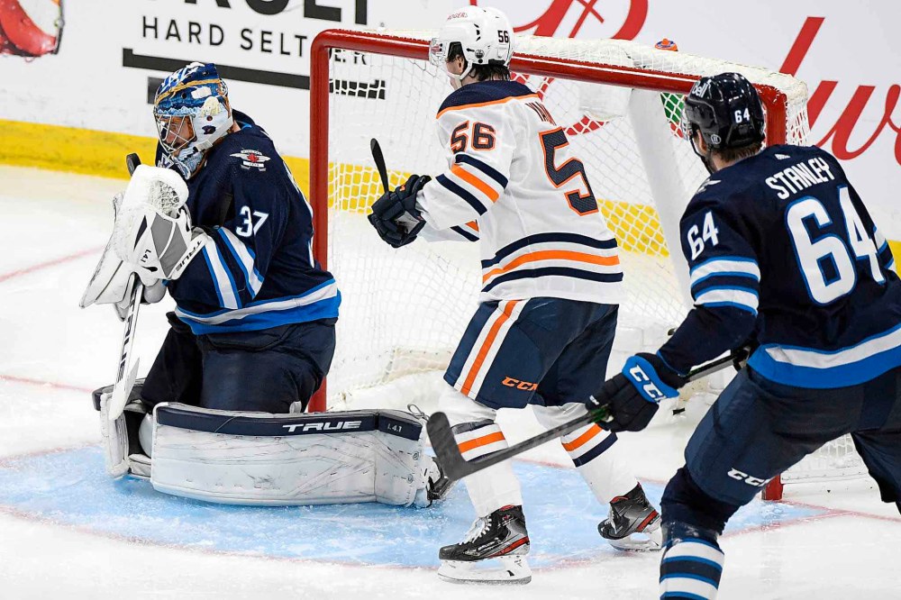 Connor Hellebuyckmakes a save as Kailer Yamamoto looks for the rebound during the third period Monday. (Fred Greenslade / The Canadian Press)
