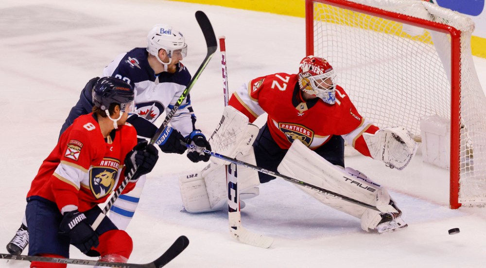 Florida Panthers goaltender Sergei Bobrovsky (72) kicks aside a shot by Winnipeg Jets left wing Pierre-Luc Dubois (80) as Panthers defenseman Ben Chiarot (8) skates in during the third period of an NHL hockey game Friday, April 15, 2022, in Sunrise, Fla. (AP Photo/Reinhold Matay)